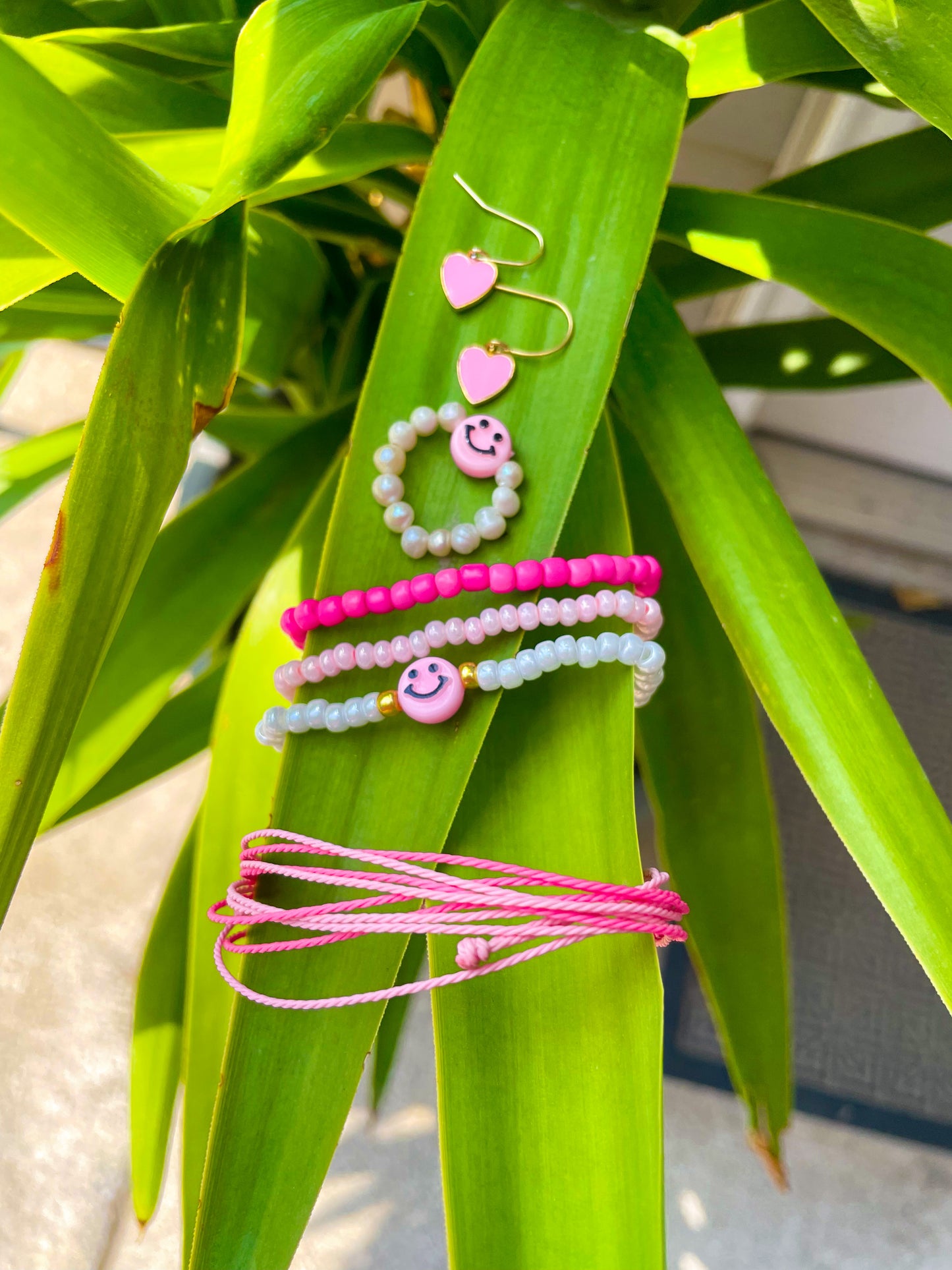 Pink smiley face bracelet stack