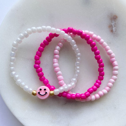 Pink smiley face bracelet stack